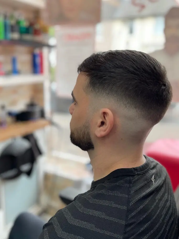 Side view of a skin fade with a textured, swept-back top